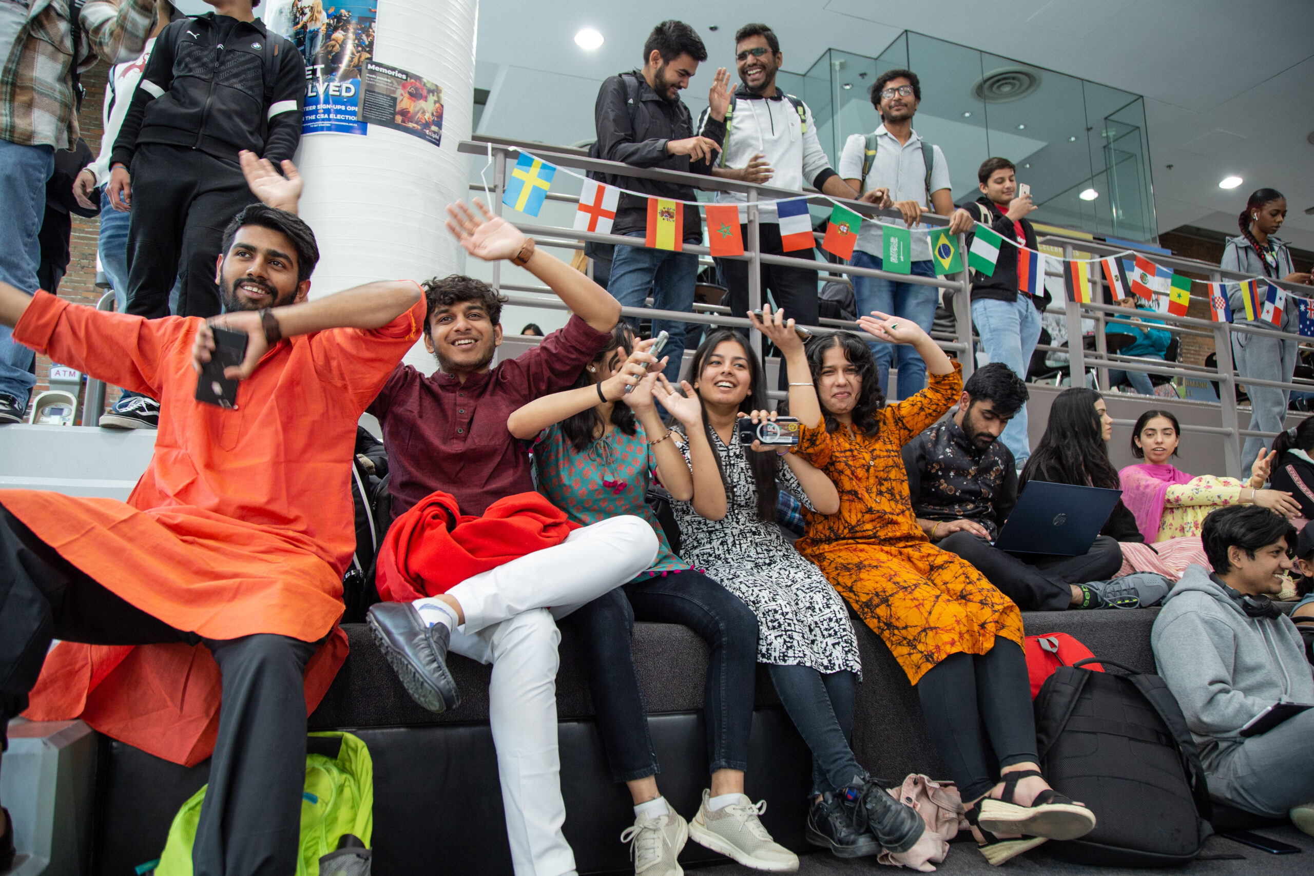 A group of international students celebrate in Tegler Student Centre.