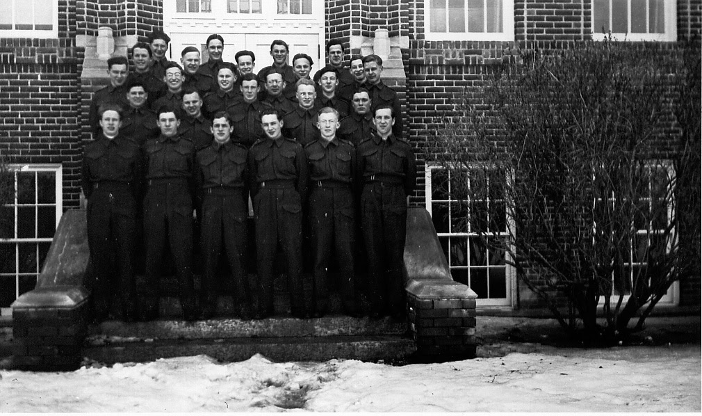 The men of the concordia platoon in a group photo on a set of stairs in front of a brick building.